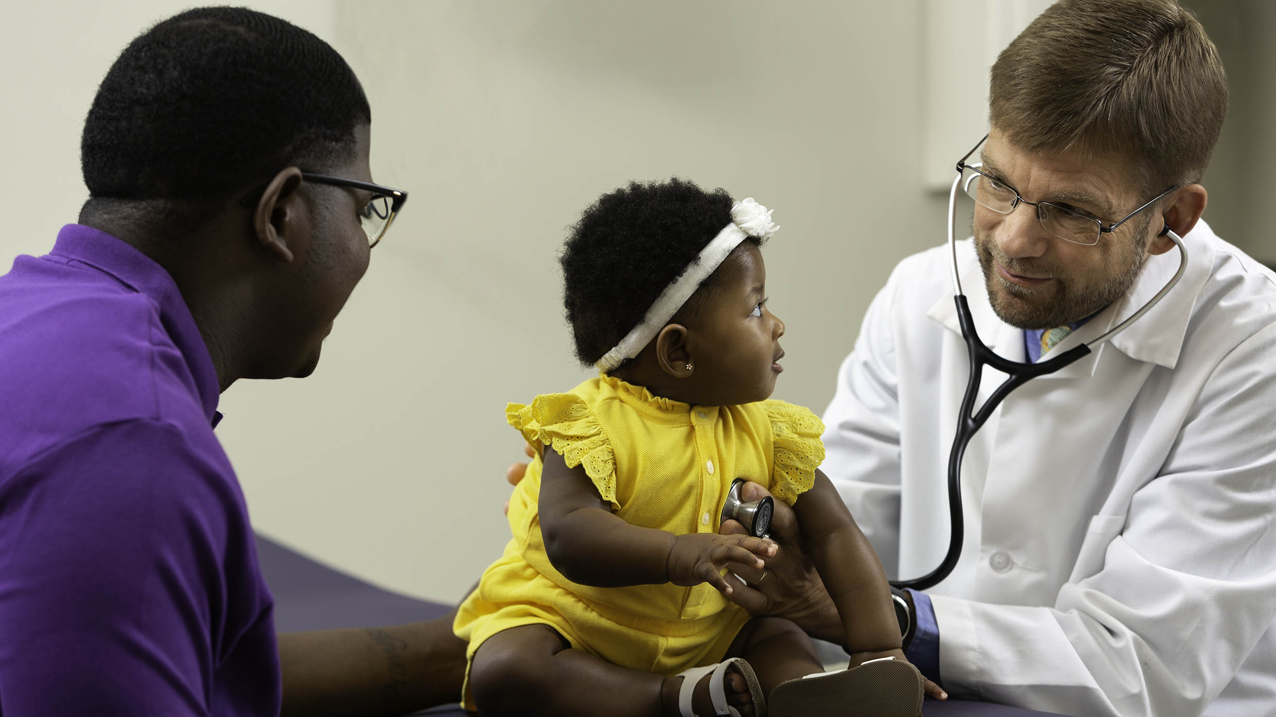 Photo of pediatrician with baby and dad
